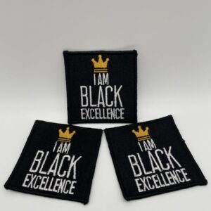 Three black excellence patches sitting on top of a table.