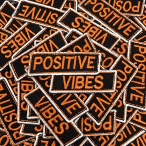 Patches with the phrase 'Positive Vibes' scattered randomly.