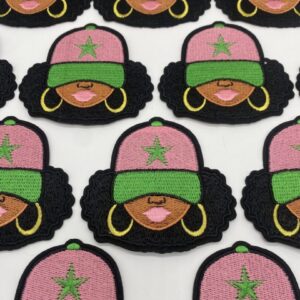 Embroidered patches of a woman with pink hat, hoop earrings, and afro hairstyle.